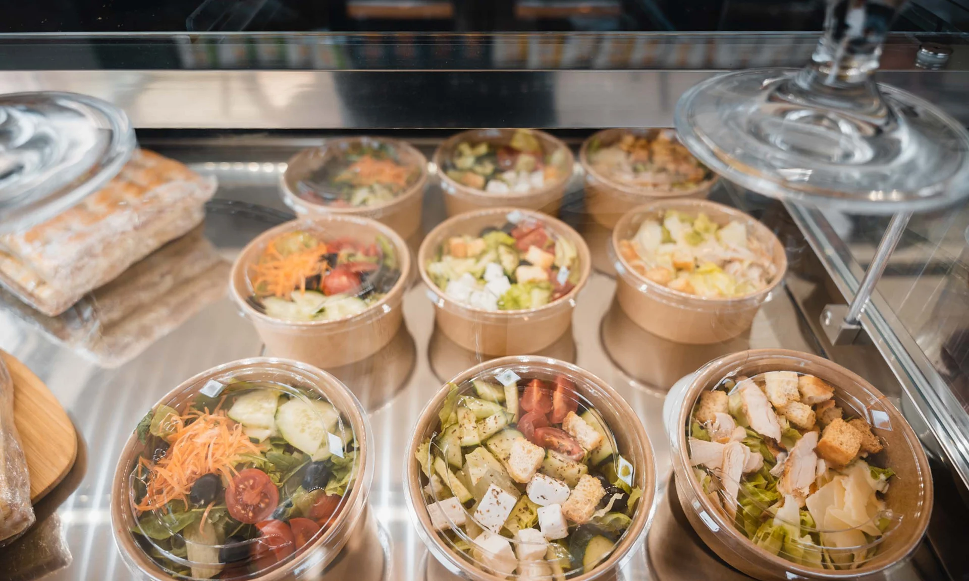 Verschiedene fertige Salate in Plastikbehältern in der Vitrine