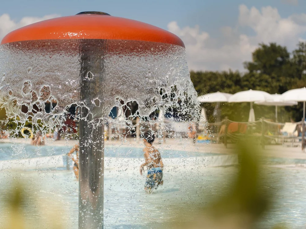 Sport & more at Natural Village Resort Water flowing from mushroom-shaped fountain in pool with children playing