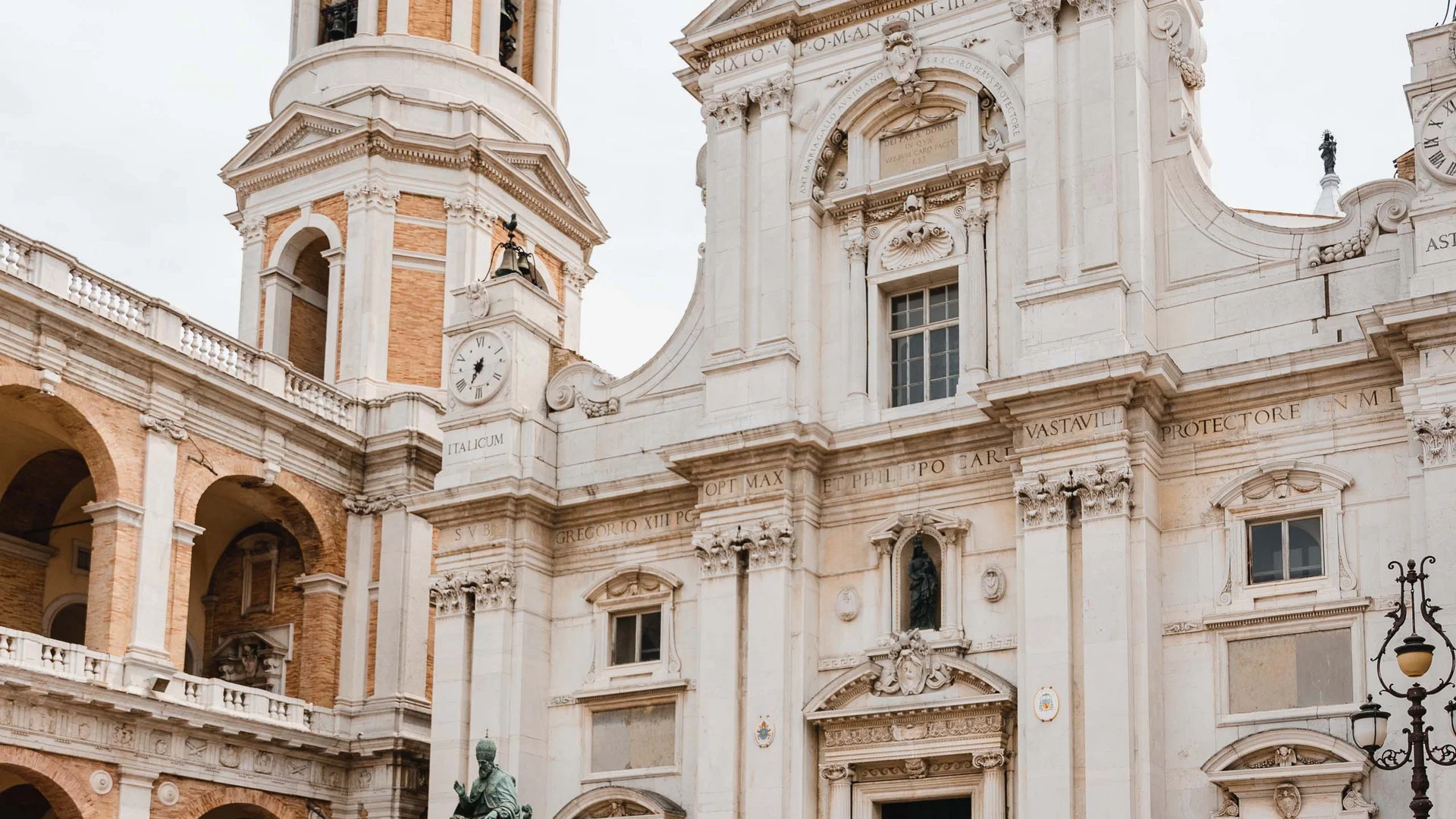 Coppia passeggia davanti a una chiesa storica con torre e statua
