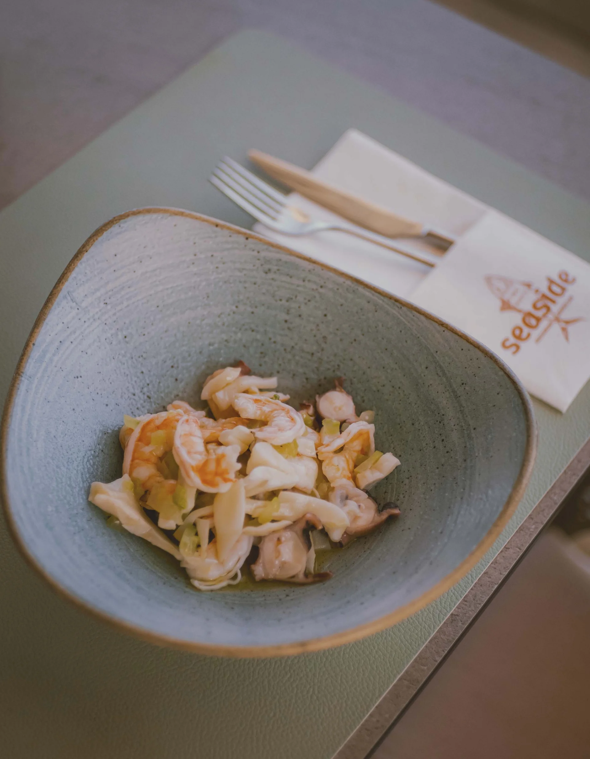 Meeresfrüchtesalat mit Garnelen und Tintenfisch in grauer Schale