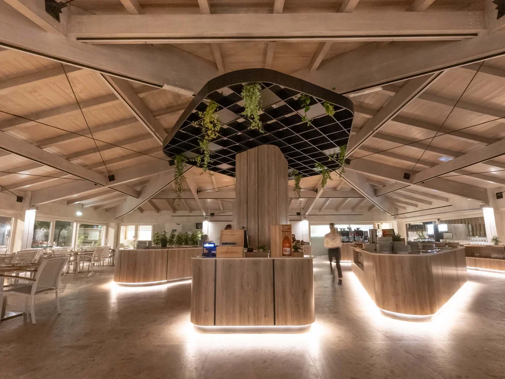 Garden Restaurant: eines der Lokale in unserem Resort Modernes Restaurant innen mit warmer Beleuchtung und Holzmöbeln