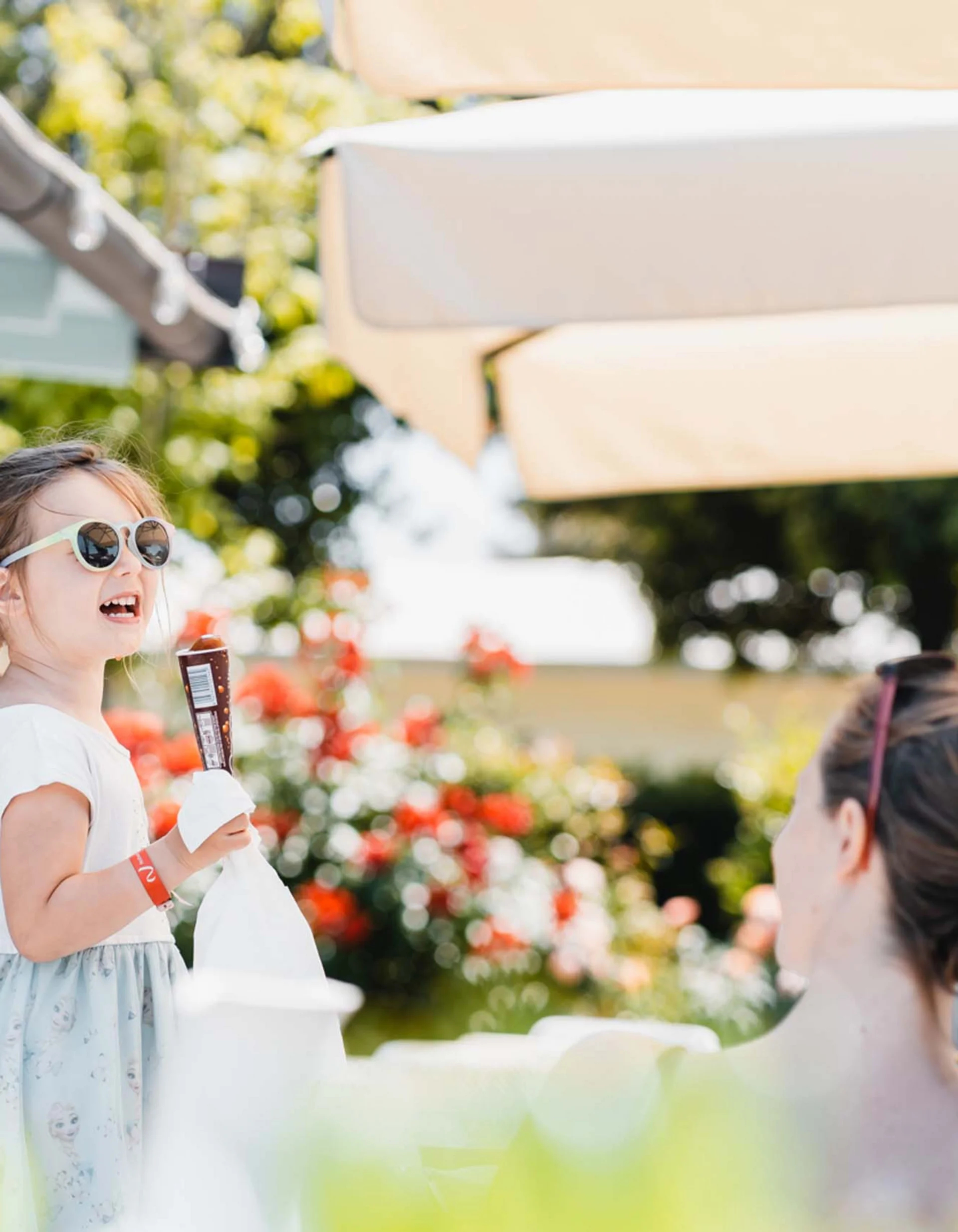 Mädchen mit Sonnenbrille isst Eis im Freien