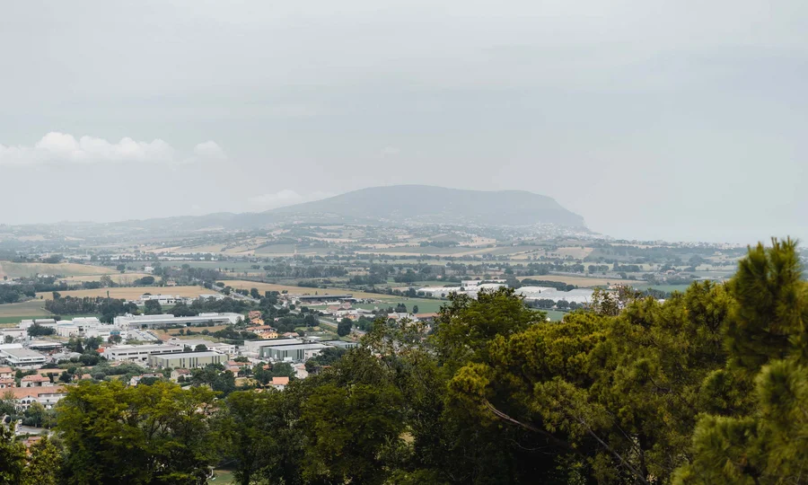 Panoramablick auf Land mit Hügeln, Gebäuden und grünen Bäumen