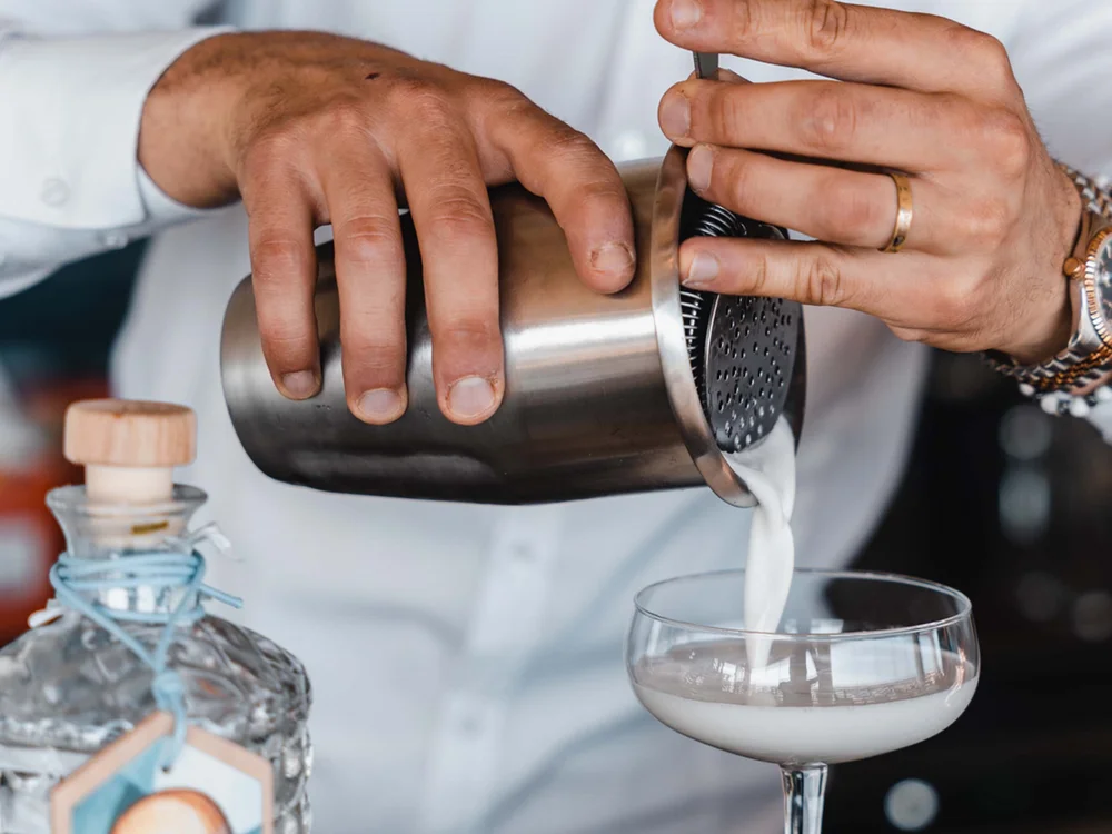 Barista versa un cocktail cremoso in un bicchiere da coppa